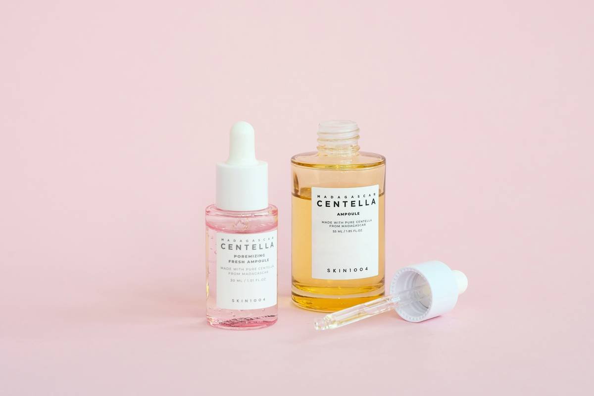 Woman applying natural cleansing facial toner with hands to damp skin
